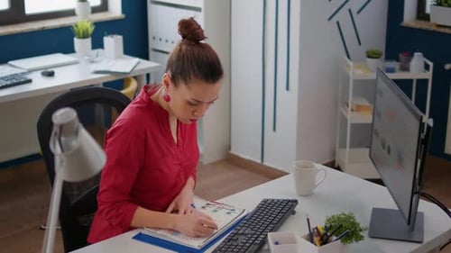 Woman Analyzes Data at Desk in Modern Office