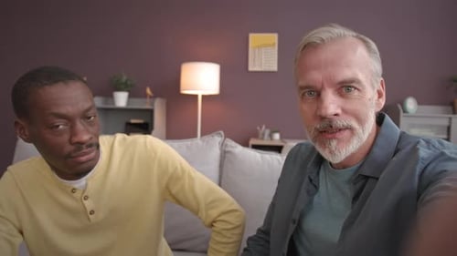 Two Men Talk on Sofa, Shake Hands