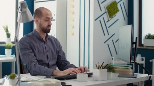 Man Typing At Computer in Modern Office