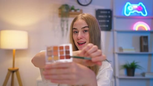 Joven bloguera de belleza caucásica graba contenido en vídeo sobre cosmética.