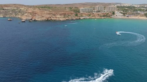 Jet Ski With White Wake In The Sea In Riviera Beach In Malta - Aerial Drone Shot