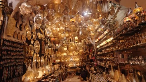 A Moroccan market stall filled with brass lanterns, mosaic lamps, and intricate decorative crafts.