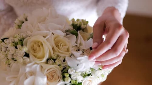 Bride's Hand Adjusts Wedding Bouquet Close Up