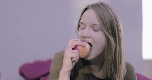 Young Woman Eating a Fresh Apple Close Up