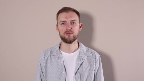 Man showing hush gesture on beige background