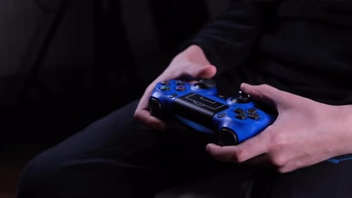 Closeup of the Hands of a Boy or Teenager Playing a Game Console