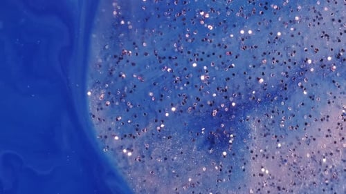 Abstract Glitter Particles on Deep Blue Liquid