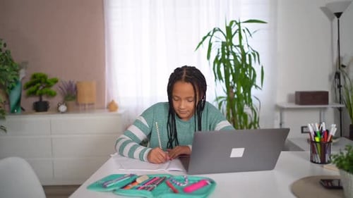 Teen Girl Studies with Laptop at Home Indoors