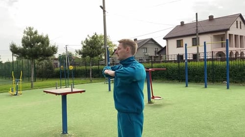 A male athlete warms up at the outdoor gym