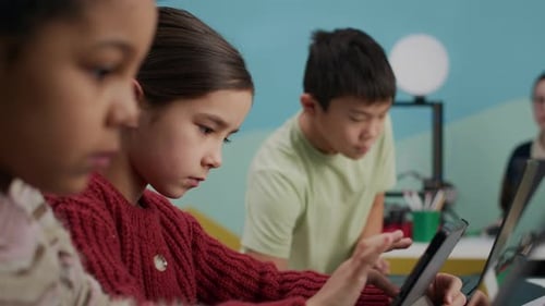 Vielfältige Grundschüler nutzen Laptops im modernen digitalen Klassenzimmer