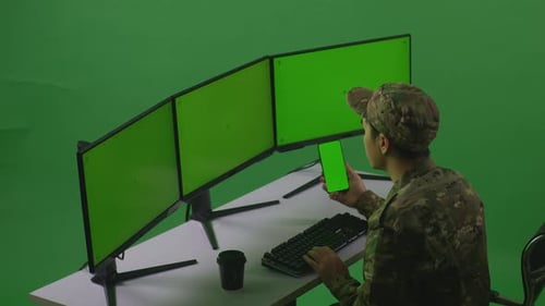 Asian Man Soldier Using Mobile Phone And Multiple Monitor With Mock Up Green Screen In Green Screen