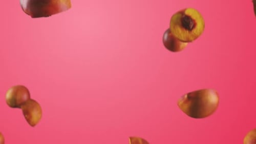 Falling Fresh Peaches Against a Vibrant Pink Background