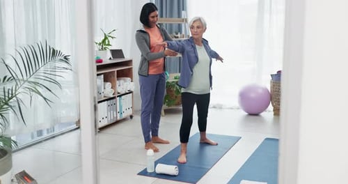 Senior Woman Stretching with Coach in Bright Studio