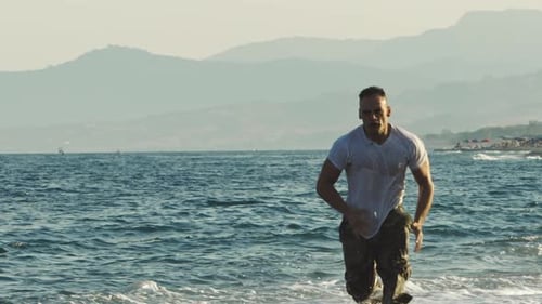 Athletic Man Exercising on a Rocky Beach