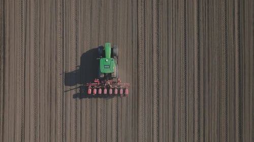 Tractor cultivating striped field