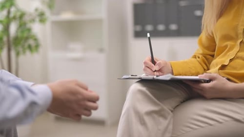 Therapist Taking Notes During Patient Discussion