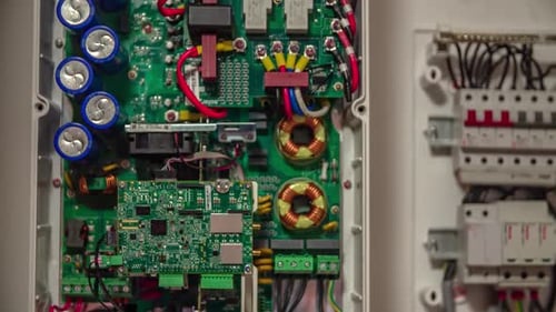 View Of Open PCB Solar Panel Junction Box Next To Fuse Box. Follow Shot Up