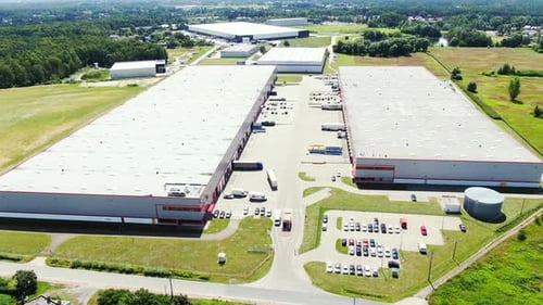 Aerial Shot of Truck with Attached Semi Trailer Leaving Industrial Warehouse Storage Building Loadin