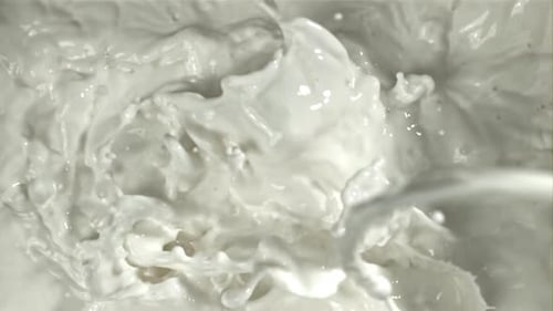 Frische Milch mit Spritzern, gefilmt mit einer Hochgeschwindigkeitskamera mit 1000 Bildern pro Sekunde