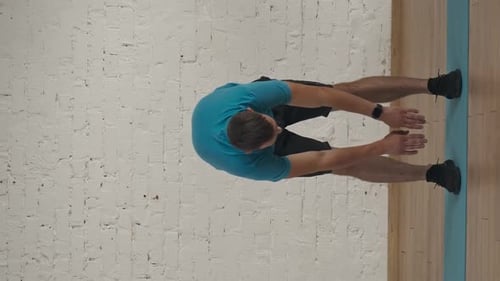 Vertical Video Man Fitness Coach in Sportswear Doing Back Stretch Warm Up for Online Class at the