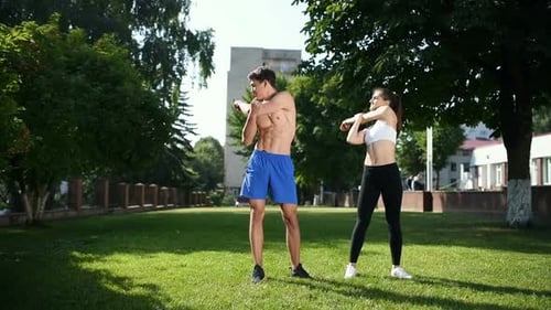 Man and woman doing stretching in the city at daytime in the park