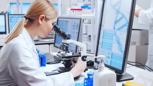 Scientist Works With Microscope in Modern Laboratory