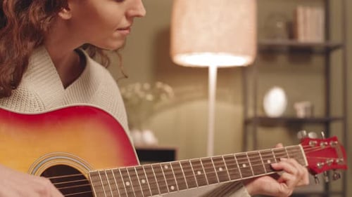 Woman Plays Acoustic Guitar Indoors at Home