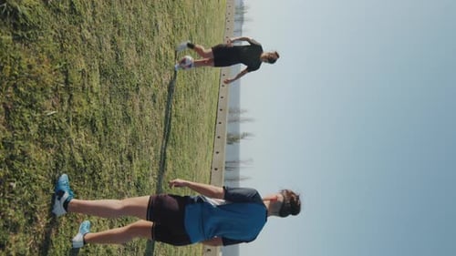 Two Athletic Girls Passing Soccer Ball on Sunny Day