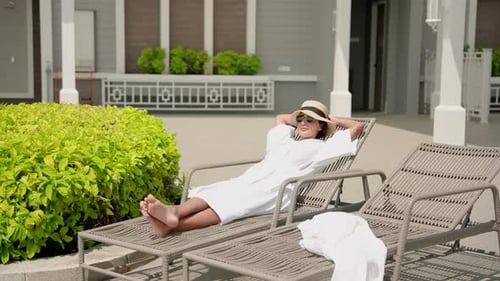Woman Relaxing on Lounge Chair by Poolside