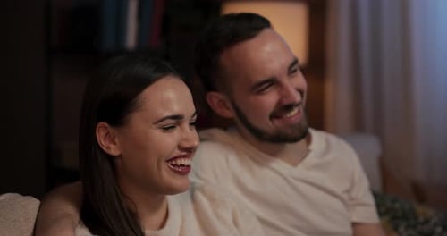 Laughing Couple Relaxing on a Couch at Home
