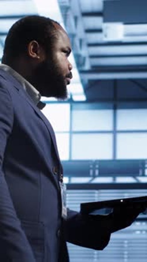 Man Works with Laptop in Dark Server Room