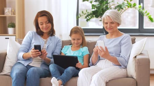 Three Generations Using Technology Together on Sofa