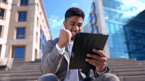 Man, tablet and celebrate success outdoor in city or online for competition, trading or invest