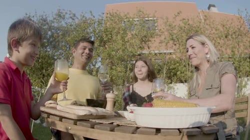 Father Saying Toast and Family Clinking Glasses at Garden Party