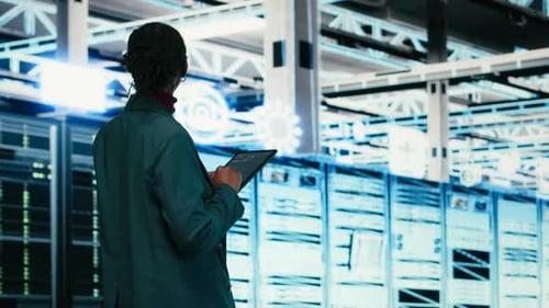 Female Programmer Walking in Data Center Using Tablet to Write Code