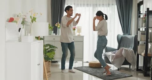 Happy Couple Dancing Together in Home Living Room