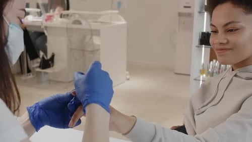 Pregnant Young Smiling African American Woman is at the Nail Beauty Studio