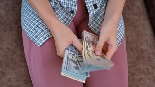 Woman Counting Stack of United States Currency Money