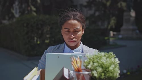 Unemployed African American Woman Holding Office Supplies