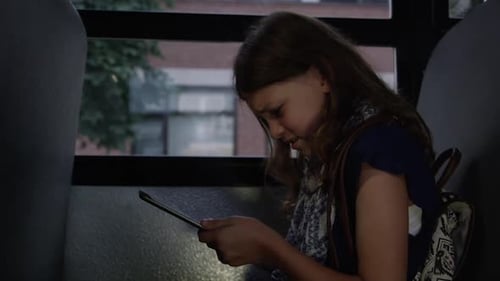 kids on the school bus - Cyber bullying one girl on tablet