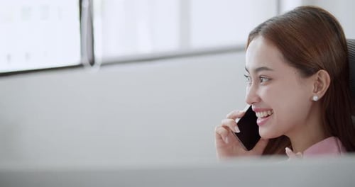 Young Adult Woman Talking on Cell Phone at Work
