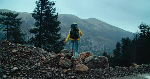 Woman Hikes on Mountain Edge to Take in View at Autumn Travel Adventure