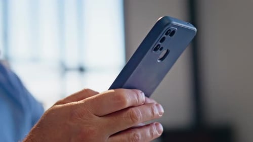 Mann reicht Messaging-Smartphone, sitzender Büro-Nahaufnahme, Chef, der Telefon benutzt