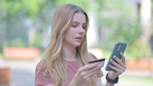 Woman Using Smartphone and Credit Card Outdoors
