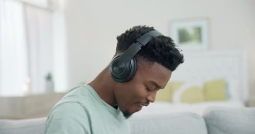 Black man, headphones and dancing to music, relax at home with audio streaming and stress relief
