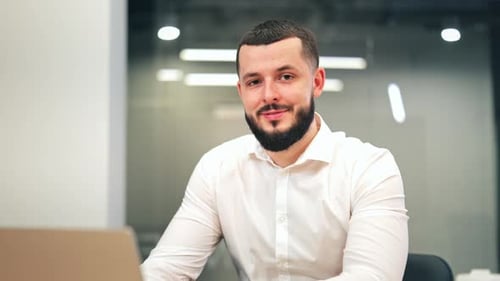 Confident Businessman Smiling at Modern Office Desk