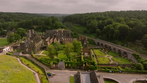 Villers Abbey Ruins Stand Amidst Lush Greenery Camera Pans Across Capturing the Serene Beauty of the