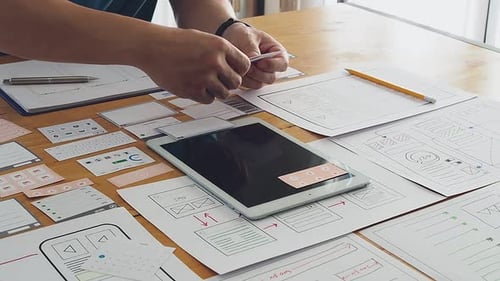 Diseñador de UX o UI que diseña una aplicación en tableta con un prototipo de diseño de maqueta.