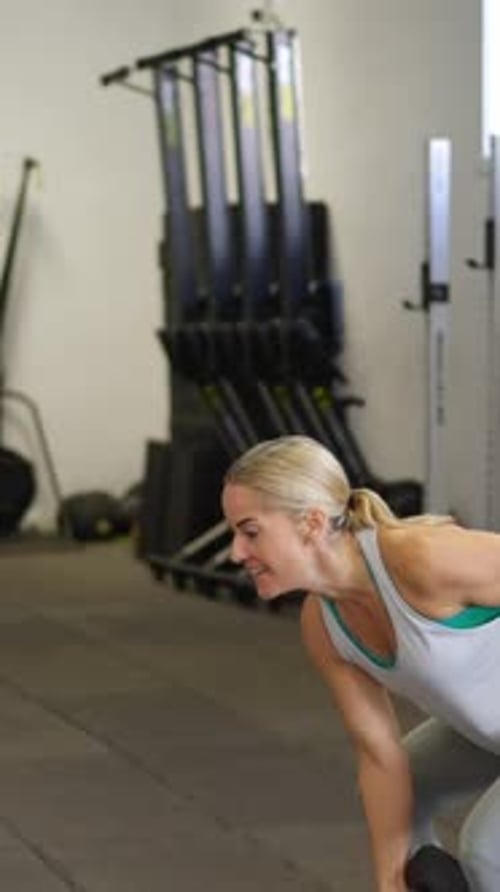Woman Lifting a Dumbbell During Gym Workout Session