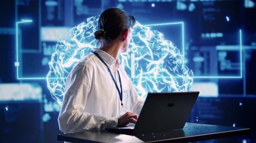 Adult Types on Laptop in Front of Digital Brain